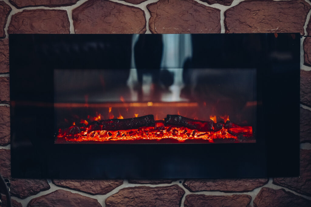 Fireplace with burning logs. Close-up of stony fireplace with burning or smoldering logs on fire.